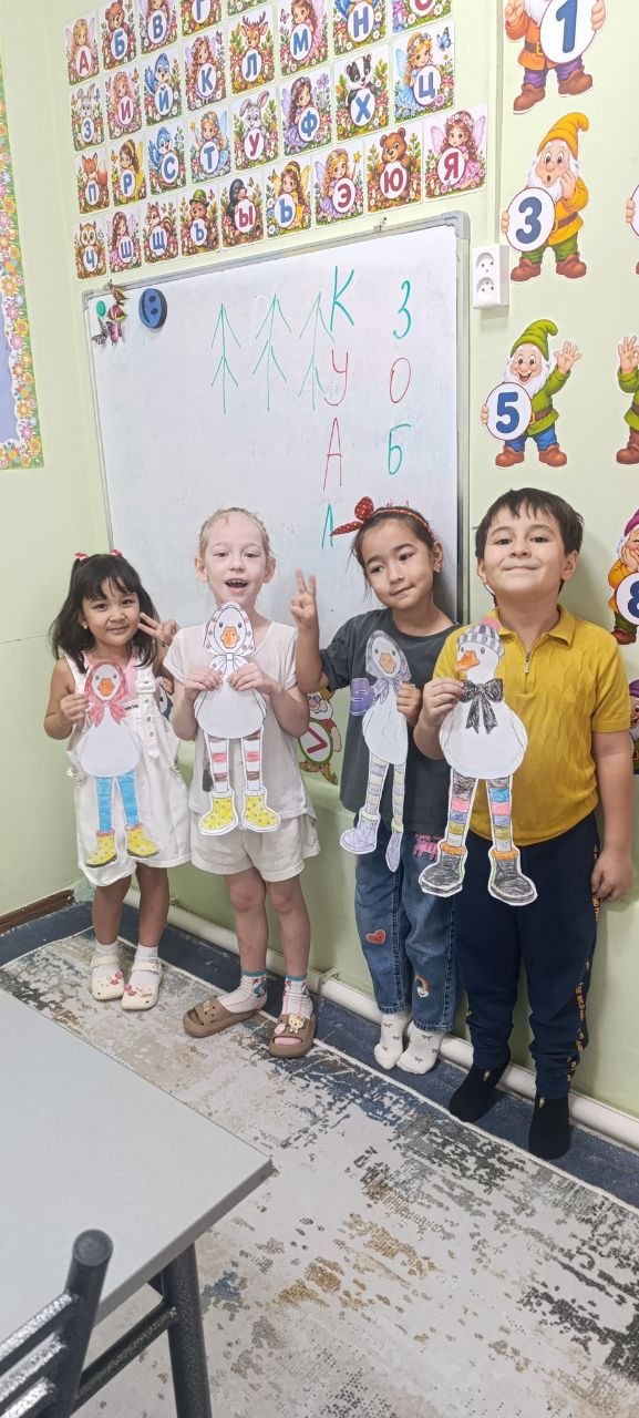 Дети показывают бумажные поделки на занятии